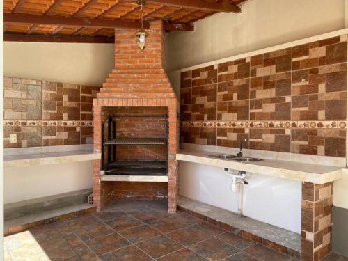 a kitchen with a brick fireplace and a sink at Preciosa casita en Zona Residencial de La Paz in La Paz