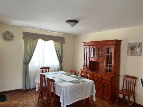 拉巴斯的住宿－Preciosa casita en Zona Residencial de La Paz，一间带桌椅和窗户的用餐室