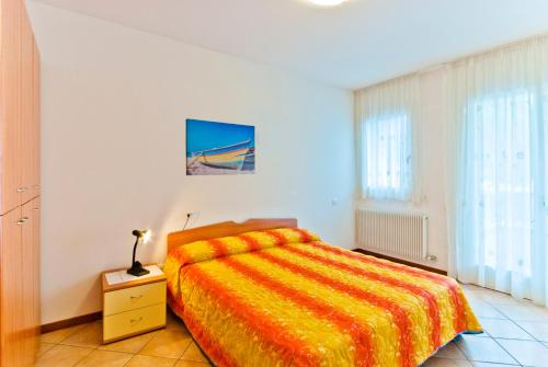 una camera con un letto e una coperta arancione di Residence Caravelle a Caorle