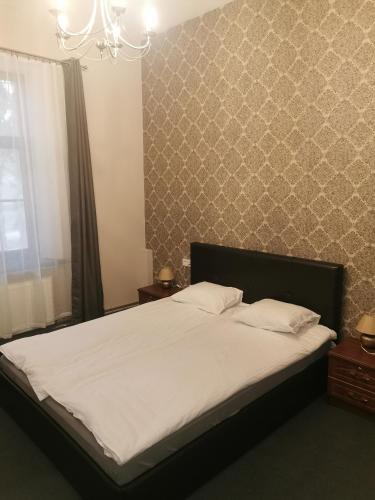 a bedroom with a large bed with white sheets at Hotel Kārklu Muiža in Jelgava