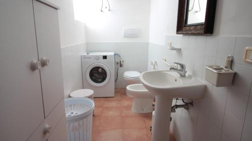 een badkamer met een wastafel en een wasmachine bij KALI Srl Società Agricola in Castiglione della Pescaia