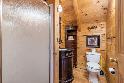 a bathroom with a toilet in a log cabin at Bear Paw Trail in Sevierville