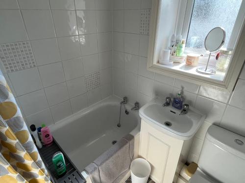 La salle de bains est pourvue d'une baignoire blanche et d'un lavabo. dans l'établissement Cottage on the Solway Coast, à Port Carlisle