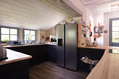 une cuisine avec un réfrigérateur en acier inoxydable et du parquet dans l'établissement AOD UHEL - Villa de Charme, Plage 20m - S24, à Carnac