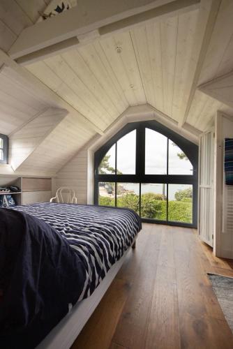 un lit dans une chambre avec une grande fenêtre dans l'établissement AOD UHEL - Villa de Charme, Plage 20m - S24, à Carnac