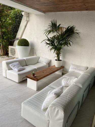 - un salon avec deux canapés blancs et une table dans l'établissement LA MAISON DE DOMS avec JACUZZI et vue mer, à Cassis