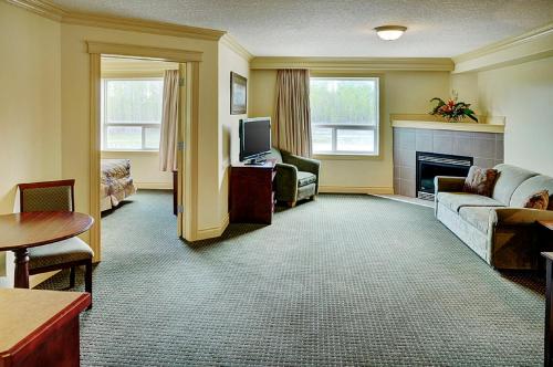 a living room with a couch and a fireplace at Nova Inn Edson in Edson