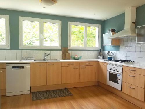 a kitchen with wooden cabinets and white appliances at Clos Mirabel Manor - Holiday rental in Jurançon