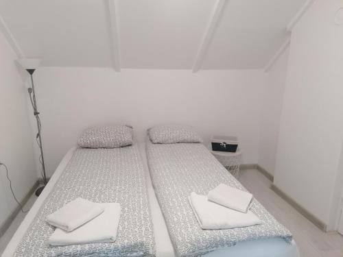 a white room with two beds with white pillows at Apartman Andrijana 1 in Soko Banja