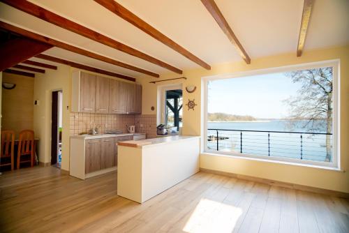 a kitchen with a large window with a view of the water at Lake House Listomie in Kruszwin