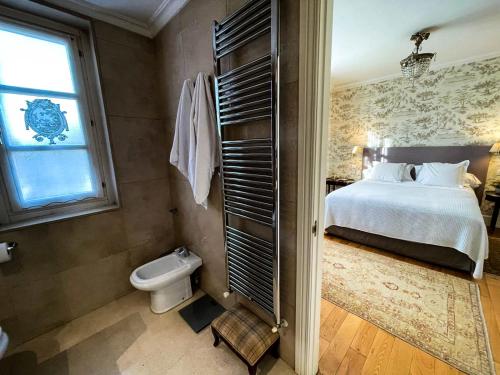 a bedroom with a bed and a toilet and a window at La Casa de Somio in Gijón
