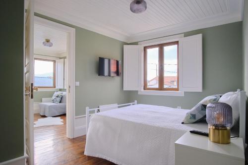 1 dormitorio con cama blanca y ventana en Casa D'Alice, en Vouzela