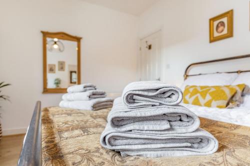 a pile of towels sitting on top of a bed at Postman's Cottage in Bridlington