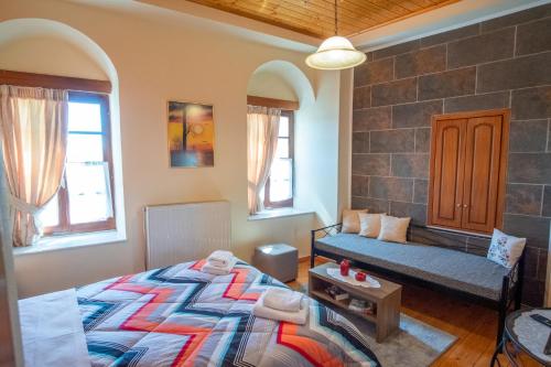 a bedroom with a bed and a bench in it at Gkoura hotel in Syrrako