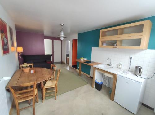 een keuken en eetkamer met een tafel en een keuken en een tafel en stoelen bij Le Cactus Orange Appartement 2 à 4 personnes avec entrée indépendante in Cressensac