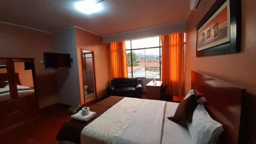 een hotelkamer met een groot bed en een raam bij Victtorios Hotel in Satipo