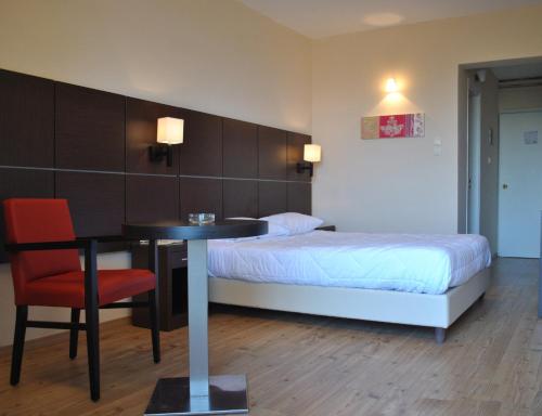 a bedroom with a bed and a table and a bed and a chair at Belle Helene Hotel in Vathi, Mani