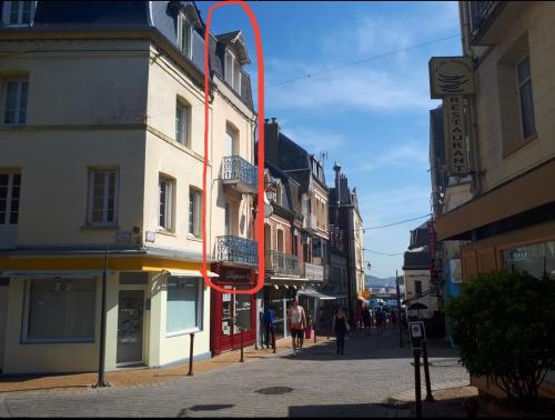 una flecha roja en el lado de un edificio en una calle en Diapason Location Le Tréport pour 5 personnes en Le Tréport