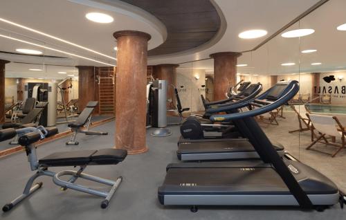 a gym with a row of treadmills and exercise bikes at Gai Beach Hotel in Tiberias