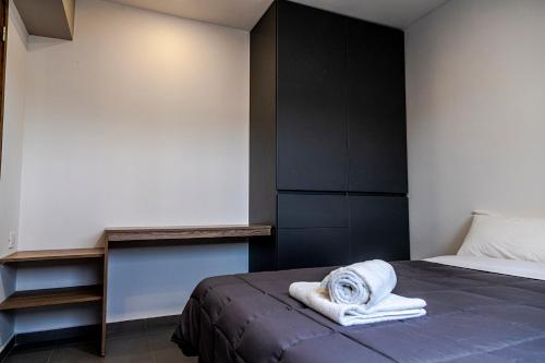 a bedroom with a bed with a towel on it at Villanueva Aparts LUX 4 in Ciudad Lujan de Cuyo