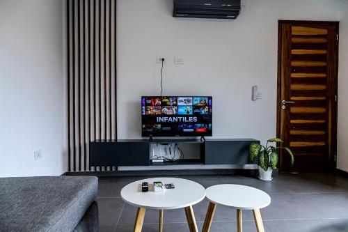 a living room with a couch and a tv and two tables at Villanueva Aparts LUX 4 in Ciudad Lujan de Cuyo