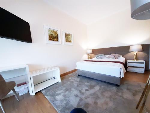a bedroom with a bed and a flat screen tv at Cerca da Estrela in Matança
