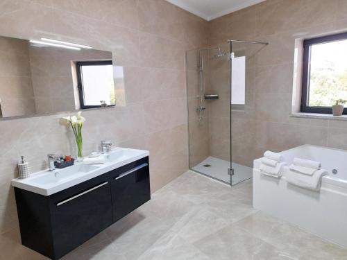 a bathroom with a tub and a sink and a shower at Cerca da Estrela in Matança