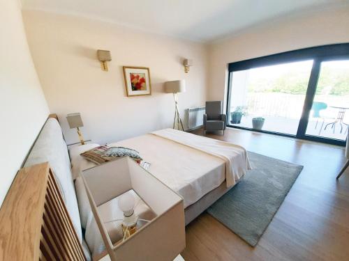 a bedroom with a large bed and a large window at Cerca da Estrela in Matança