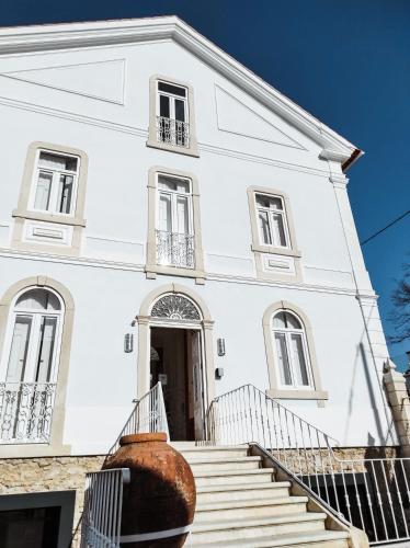 a white building with a staircase in front of it at Casa de São Bento by PURUS in Coimbra