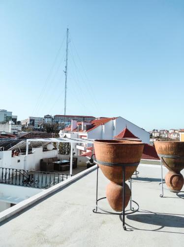 two large pots sitting on top of a roof at Casa de São Bento by PURUS in Coimbra