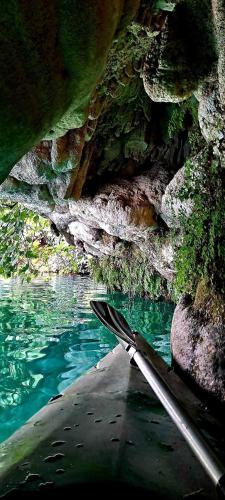 a boat in a river next to a cave at El Mirador De Ruidera in Ruidera