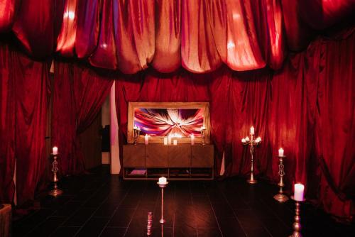een rode kamer met rode gordijnen en kaarsen erin bij Kings Mansion for 26 guests! in Tulum