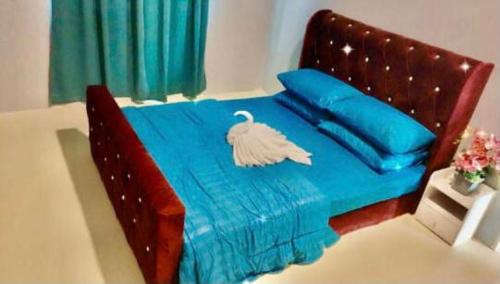 a bed with blue sheets and a swan on it at HomeStaytion@Semenyih in Lengging