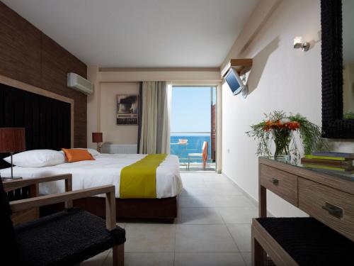 een slaapkamer met een bed en uitzicht op de oceaan bij Belle Helene Hotel in Vathi
