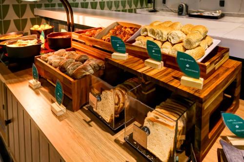 un bufé con varios tipos de pan y pasteles en Hilton Garden Inn Rebouças, en São Paulo