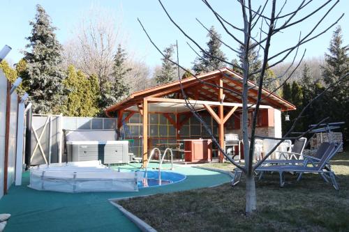 ein Haus mit einem Pool und einem Pavillon in der Unterkunft Tornyos Vendégház in Eplény