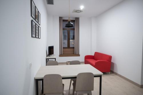 una sala da pranzo con tavolo e sedia rossa di PALACIO REAL HOSTEL a León