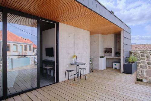 a patio with a table and chairs on a wooden deck at Casa Espelho D'Água in Vouzela