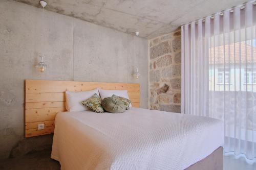 a bedroom with a large white bed with two pillows at Casa Espelho D'Água in Vouzela