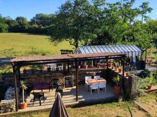 um pavilhão com uma mesa e cadeiras num campo em Le Cactus Orange Chambre d'hôte entrée indépendante em Cressensac