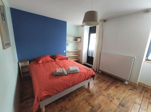 a bedroom with a red bed with a blue wall at Le Cactus Orange Chambre d'hôte entrée indépendante in Cressensac