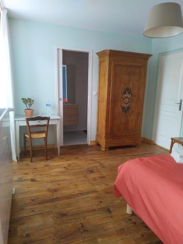 a bedroom with a bed and a table and a cabinet at Le Cactus Orange Chambre d'hôte entrée indépendante in Cressensac