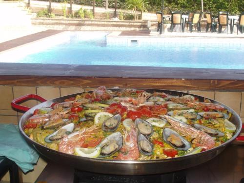 a pan of food with seafood on a table next to a swimming pool at Al Settimo Cielo in Montenero di Bisaccia