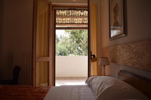 a bedroom with a bed and an open door at Villa Aurea in Ispica