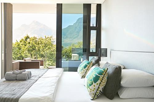 a bedroom with a bed with a view of mountains at Bayview Boutique Guesthouse in Cape Town