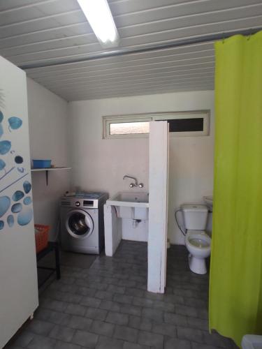 a bathroom with a sink toilet and a washing machine at MOOREA - Fare Te Utuafare in Hauru