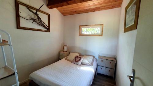 Habitación pequeña con cama y ventana en L'ANNEXE de L'IBIE BLEUE, en Lagorce