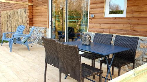 una mesa azul y sillas en un patio en L'ANNEXE de L'IBIE BLEUE en Lagorce