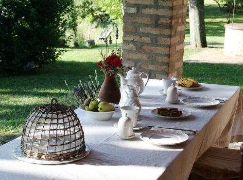 een witte tafel met eten en een vogelkooi erop. bij Cornio Delle Fronde in Fontecorniale