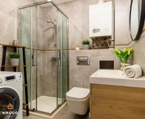 a bathroom with a shower and a toilet and a sink at Apartament Diva 12 in Mielno